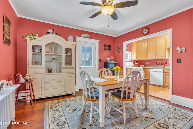 dining room with light wood-type flooring, ornamental molding, and a ceiling fan