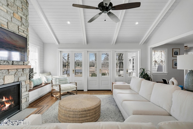 living room featuring a healthy amount of sunlight, a fireplace, and lofted ceiling with beams