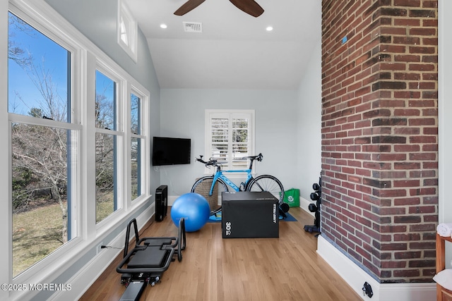 exercise area with visible vents, wood finished floors, ceiling fan, and vaulted ceiling