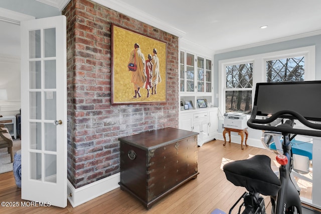 office area featuring hardwood / wood-style floors, crown molding, baseboards, and brick wall