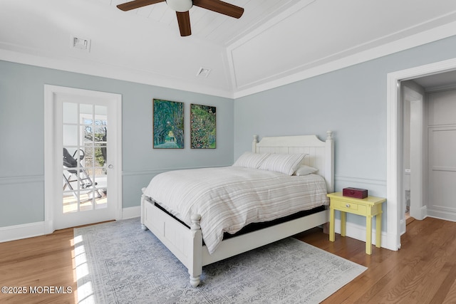 bedroom featuring visible vents, wood finished floors, vaulted ceiling, and access to outside