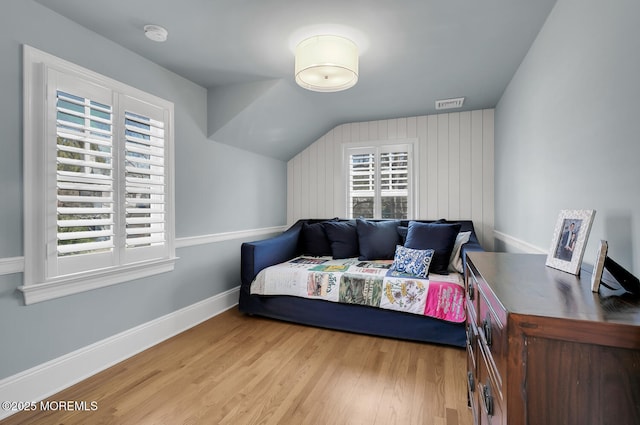 bedroom with light wood finished floors, visible vents, multiple windows, and baseboards