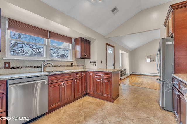 kitchen featuring visible vents, a sink, vaulted ceiling, appliances with stainless steel finishes, and tasteful backsplash