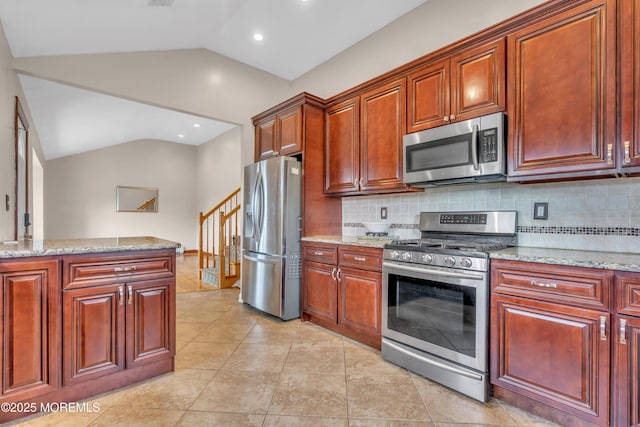 kitchen featuring tasteful backsplash, stainless steel appliances, lofted ceiling, and light stone countertops