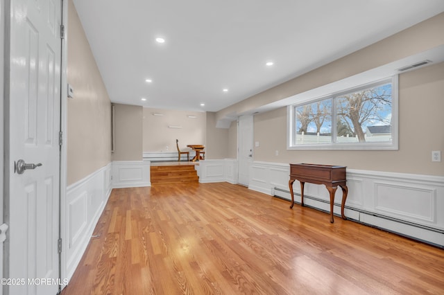 basement with light wood-type flooring, visible vents, recessed lighting, a baseboard radiator, and baseboard heating