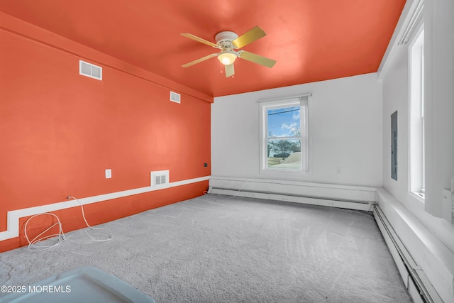 carpeted empty room with visible vents, ceiling fan, and a baseboard radiator