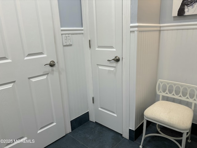 bathroom featuring tile patterned floors and a wainscoted wall