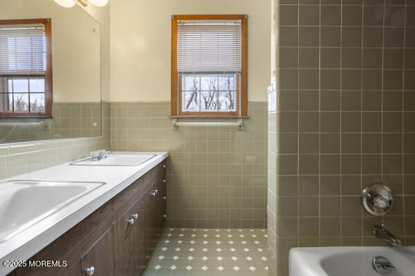 502 Monmouth Rd, West Long Branch, NJ 07764 - full bath featuring tile walls, a healthy amount of sunlight, and a sink
