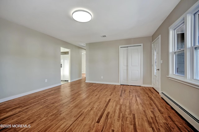 interior space featuring light wood-type flooring, visible vents, baseboards, and baseboard heating