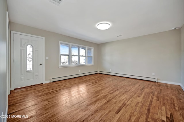 foyer entrance featuring wood finished floors, visible vents, and baseboard heating