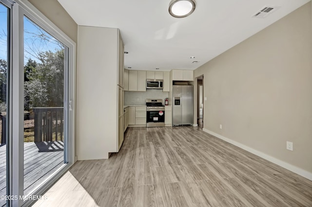 kitchen with light wood-type flooring, visible vents, stainless steel appliances, decorative backsplash, and baseboards