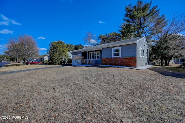 ranch-style home with brick siding, a porch, and a front lawn