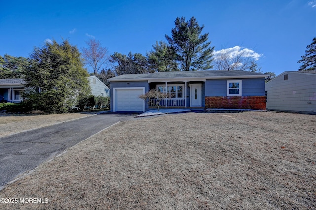 ranch-style home featuring a garage, brick siding, and driveway