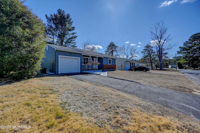 ranch-style house with a front lawn, a garage, and driveway