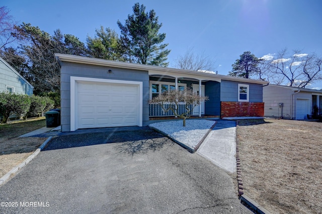 ranch-style house with aphalt driveway, an attached garage, and brick siding