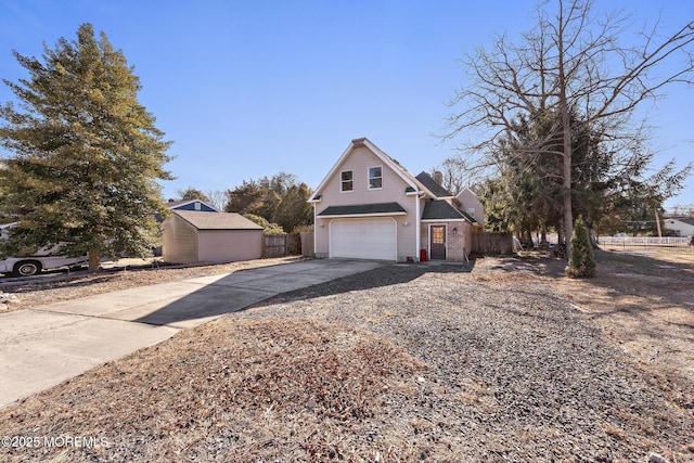 view of front of property featuring an attached garage, driveway, and fence