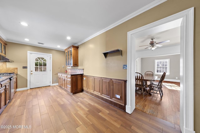 kitchen featuring a healthy amount of sunlight, light wood-style floors, visible vents, and ornamental molding