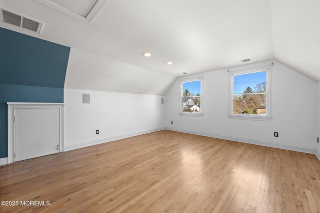 additional living space with visible vents, light wood-style flooring, and lofted ceiling