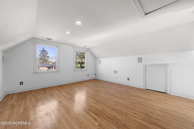 bonus room with vaulted ceiling, light wood-style floors, visible vents, and baseboards