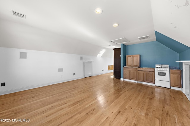 additional living space with light wood-type flooring, visible vents, and baseboards