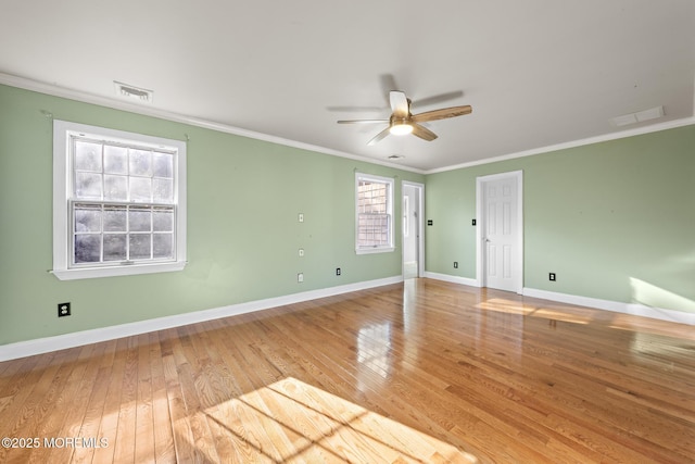 unfurnished room featuring visible vents, crown molding, baseboards, and hardwood / wood-style flooring