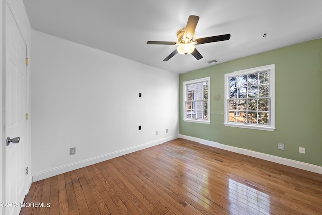 spare room featuring a ceiling fan, baseboards, and hardwood / wood-style floors