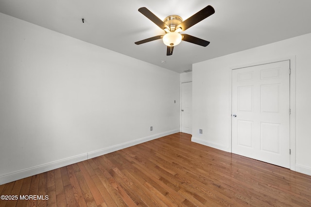 unfurnished bedroom with baseboards, wood finished floors, and a ceiling fan