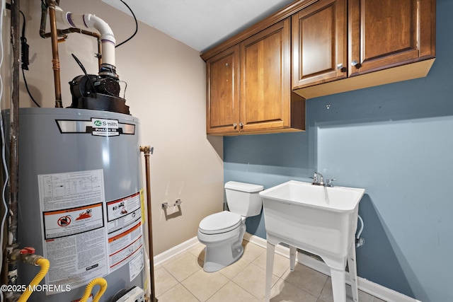 bathroom featuring gas water heater, baseboards, toilet, and tile patterned flooring