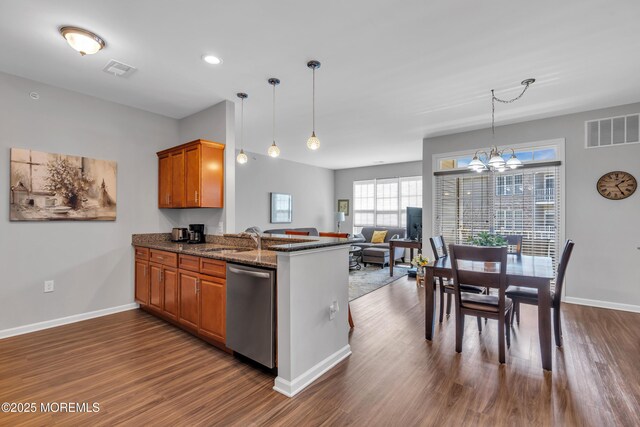 kitchen featuring visible vents, an inviting chandelier, dark wood-style flooring, dishwasher, and brown cabinets