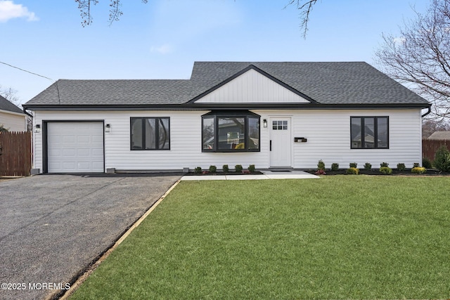 modern farmhouse style home featuring aphalt driveway, a front yard, a garage, and a shingled roof