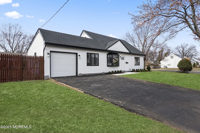 view of front facade with fence, aphalt driveway, a front yard, roof with shingles, and a garage