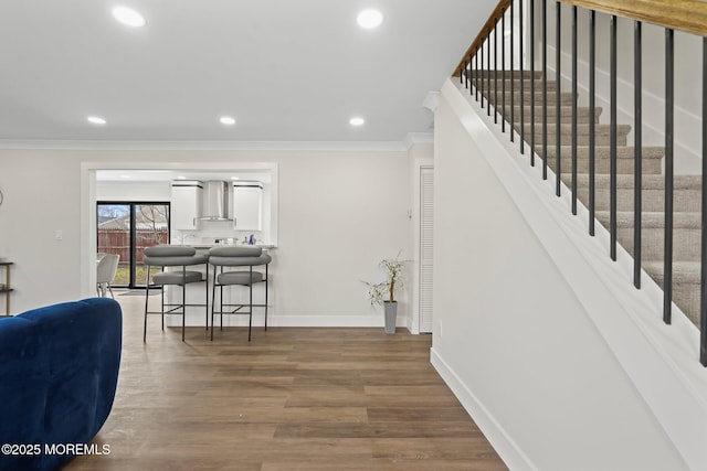 interior space featuring recessed lighting, baseboards, wood finished floors, and ornamental molding