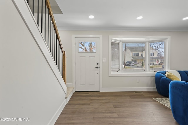 entryway featuring recessed lighting, wood finished floors, baseboards, and ornamental molding