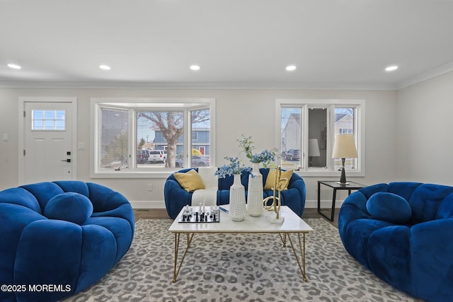 living area with crown molding, wood finished floors, baseboards, and a healthy amount of sunlight