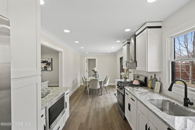 kitchen with stainless steel gas stove, a sink, light stone counters, dark wood-style floors, and built in microwave