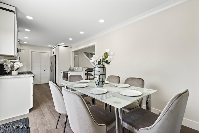 dining room featuring recessed lighting, baseboards, wood finished floors, and ornamental molding