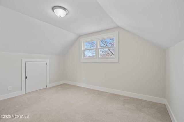 bonus room with light colored carpet, baseboards, and vaulted ceiling