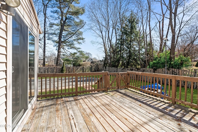 deck with a yard and a fenced backyard