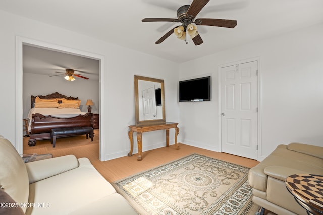 living room with light wood finished floors, baseboards, and a ceiling fan