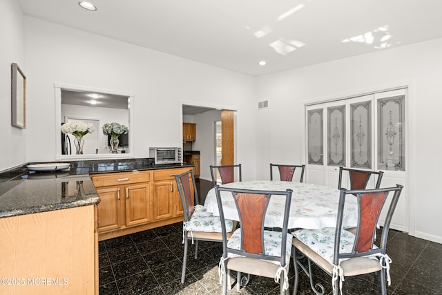 dining room featuring visible vents, granite finish floor, recessed lighting, a toaster, and baseboards