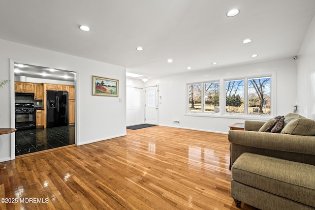 living room featuring hardwood / wood-style floors, recessed lighting, and baseboards