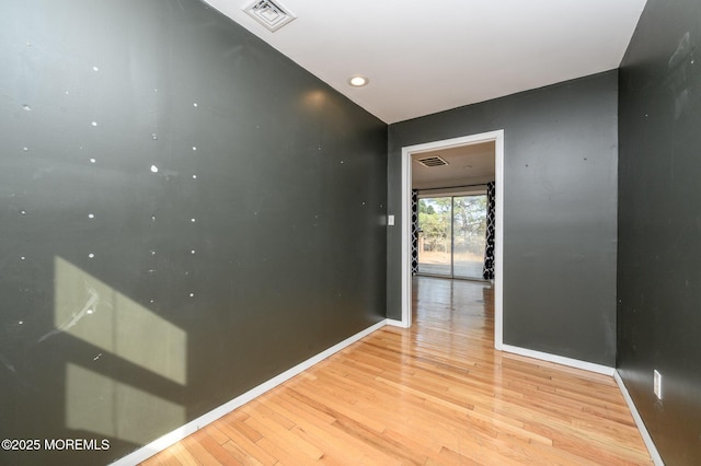 hallway with visible vents, light wood-type flooring, and baseboards