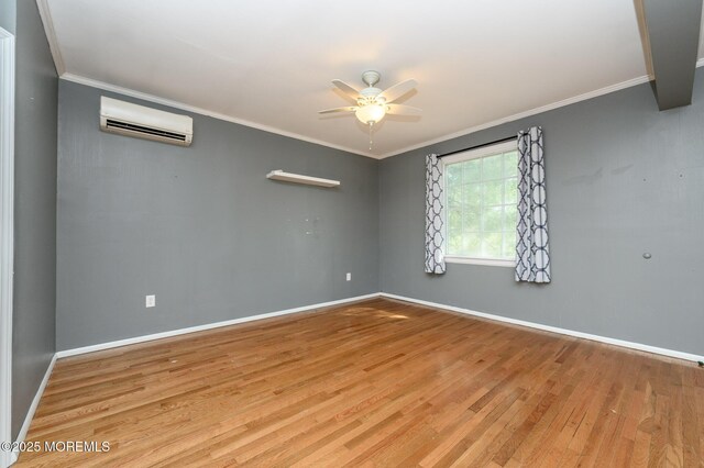 unfurnished room featuring wood finished floors, ornamental molding, a ceiling fan, and a wall unit AC