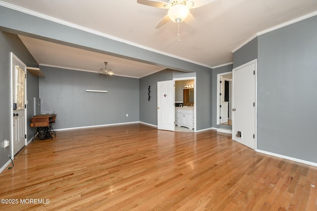 unfurnished living room with crown molding, wood finished floors, baseboards, and ceiling fan