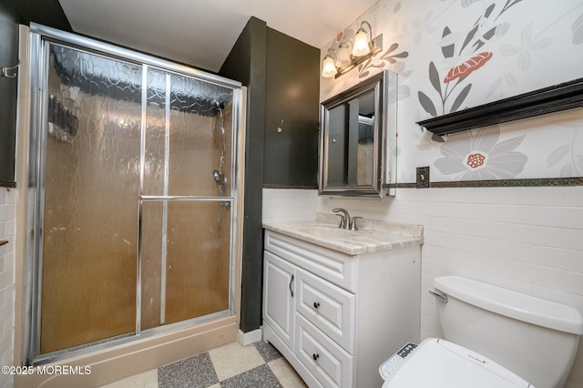 full bath featuring vanity, tile walls, a shower stall, and toilet