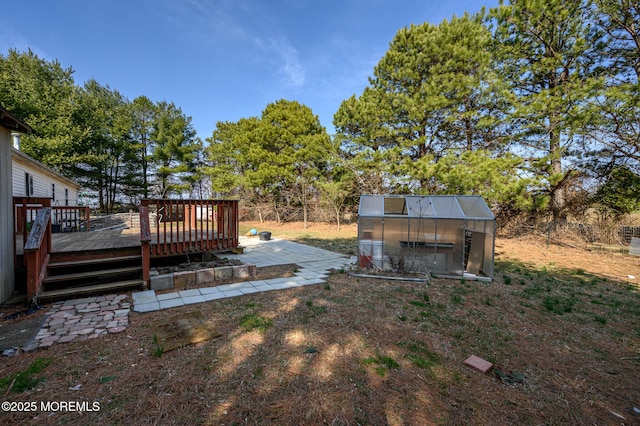 view of yard with a deck, an outbuilding, and an exterior structure