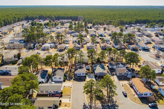 birds eye view of property featuring a forest view and a residential view