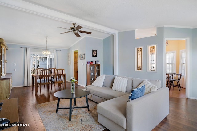 living area featuring lofted ceiling, crown molding, dark wood-style floors, and baseboards