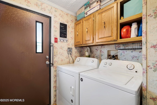 laundry area with wallpapered walls, a textured ceiling, cabinet space, and washer and clothes dryer