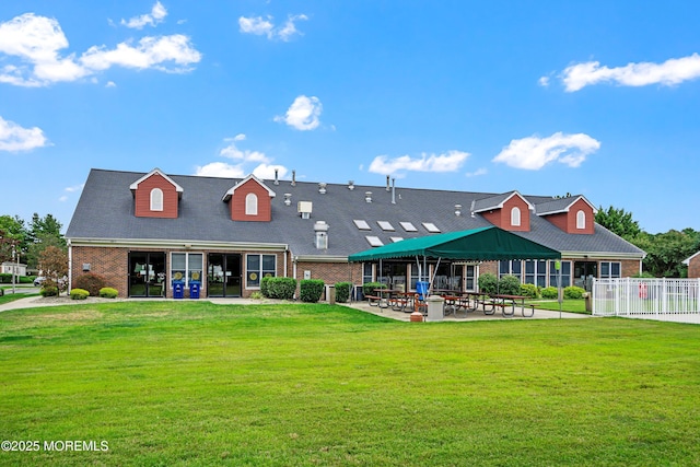 back of house featuring a gazebo, a yard, fence, and brick siding